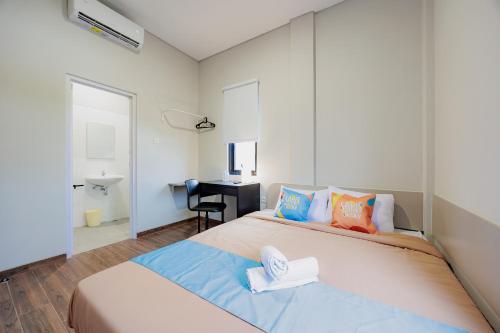 a bedroom with a large bed with towels on it at Sans Stay Bintaro in Pondoklang