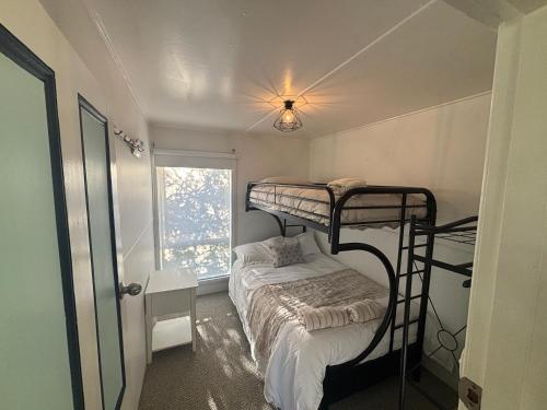 a bedroom with two bunk beds and a window at Port Sorell Beach Shack in Port Sorell
