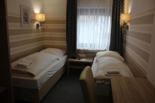 a hotel room with two beds and a window at Airport-Hotel zum Taubengrund in Kelsterbach