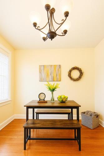 a dining room table with a bench and a chandelier at Near Stadiums and Downtown in Peaceful Neighborhood in Baltimore