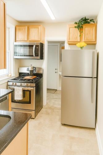 a kitchen with a stainless steel refrigerator and cabinets at Near Stadiums and Downtown in Peaceful Neighborhood in Baltimore