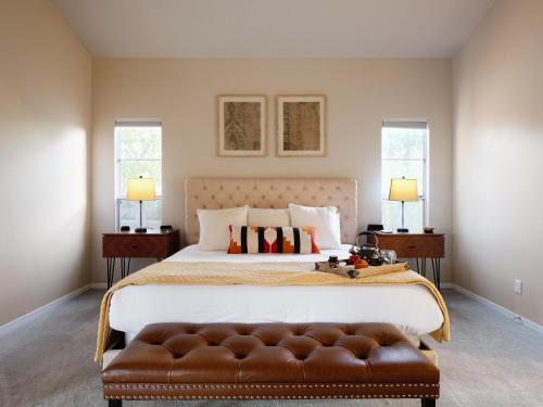 a bedroom with a large bed with a brown leather couch at Luxury Mountain Estate-Pool-Spa-BBQ+Bar-Fire pit in Scottsdale