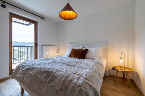 ein weißes Schlafzimmer mit einem großen Bett und einem Fenster in der Unterkunft New Ideal 2 rooms 12 4 people in Saint-Bon-Tarentaise