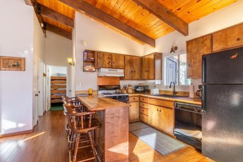 a kitchen with wooden cabinets and a black refrigerator at Bearadise Cabin in Sugarloaf