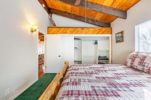 a bedroom with a bed with a checkered blanket at Bearadise Cabin in Sugarloaf