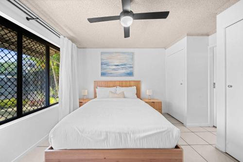 een slaapkamer met een bed en een plafondventilator bij Chambers River Retreat in Maroochydore