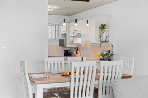 een keuken met een eettafel en stoelen bij Chambers River Retreat in Maroochydore