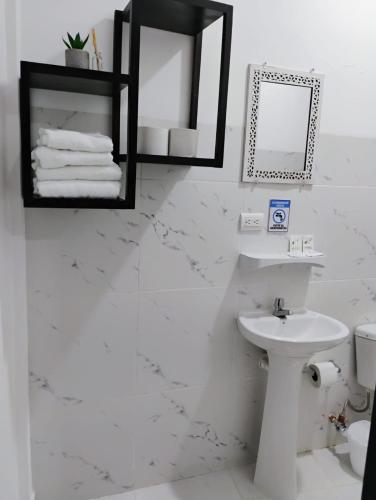 ein weißes Badezimmer mit Waschbecken und Toilette in der Unterkunft Hosteria La Veleta, Playas in Playas
