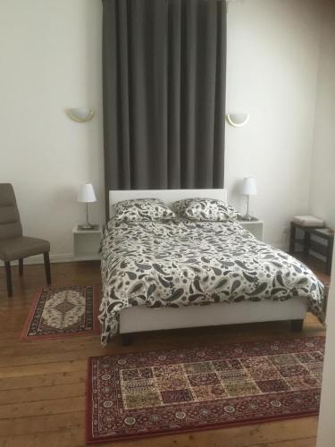 - une chambre avec un lit, une couette et un tapis dans l'établissement Résidence Chez Tante Germaine, à Strasbourg