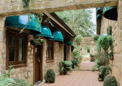 une entrée d'un bâtiment en pierre avec des plantes en pot dans l'établissement Dalat Train Village, à Đà Lạt