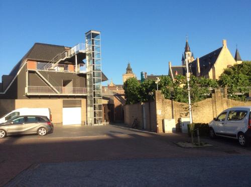 two cars parked in a parking lot next to a building at Hotel Recour in Poperinge