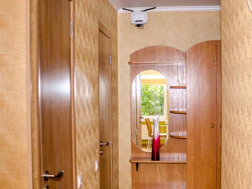 a bathroom with a mirror and a red vase on a table at Neliusi in Ventspils