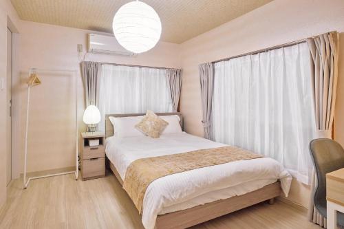 a bedroom with a white bed and a window at Hagi in Tokyo