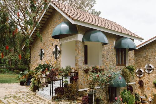 une maison en pierre avec des dômes verts dessus dans l'établissement Dalat Train Village, à Đà Lạt