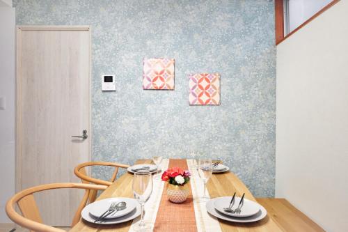 a dining room table with plates and flowers on it at Hagi in Tokyo