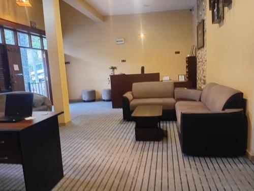 een woonkamer met banken, een bank en een tv bij NAT City Ella in Ella