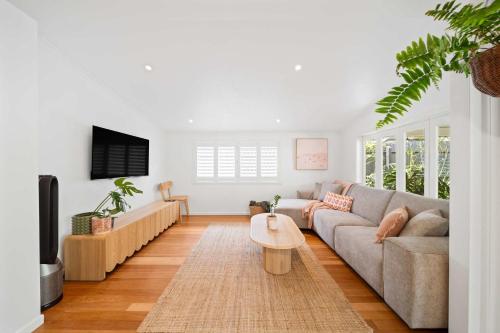 a living room with a couch and a coffee table at The Palma your Leafy Tropical Escape in Moffat Beach in Caloundra