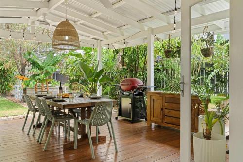a patio with a table and chairs and a grill at The Palma your Leafy Tropical Escape in Moffat Beach in Caloundra