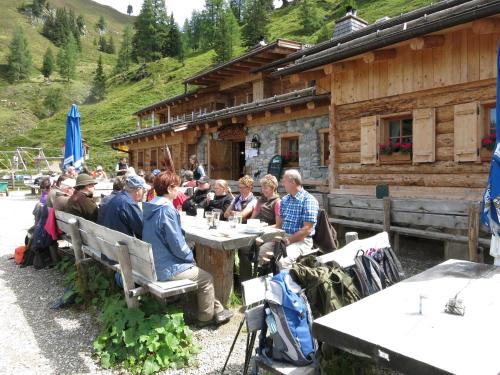 a group of people sitting at a table in front of a cabin at Salzburger Stubn in Kleinarl
