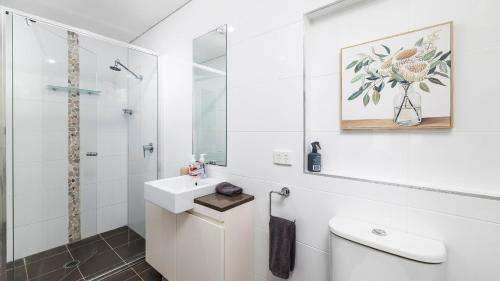 Un baño blanco con lavabo y ducha. en 4-102 Magnus Street, en Nelson Bay