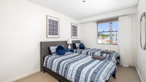 Un dormitorio con dos camas y una ventana en 4-102 Magnus Street, en Nelson Bay
