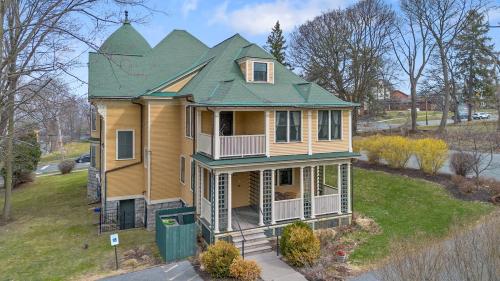 シラキュースにあるWestcott Apartments 2BD Suiteの緑の屋根の小さな黄色い家