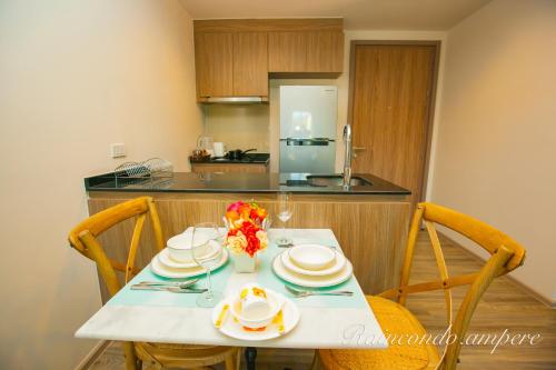 a kitchen with a table with plates and flowers on it at Raincondo Ampere in Cha Am