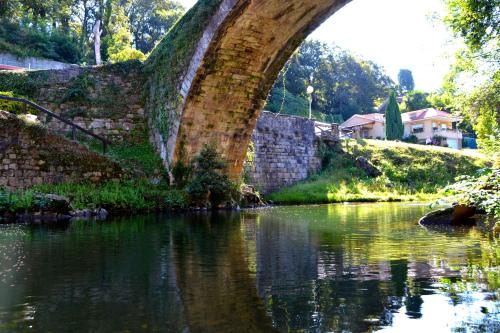 an old brick bridge over a river at Gran Hotel Balneario de Liérganes in Liérganes