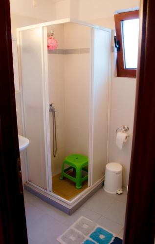 a bathroom with a shower with a green stool at Nefeli in Levidhion