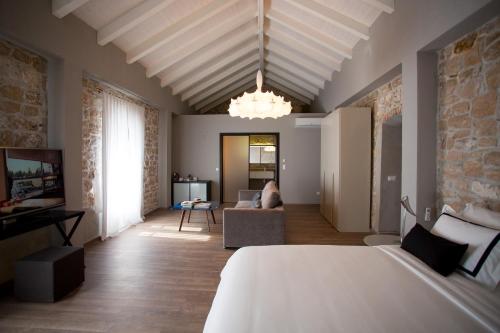 a bedroom with a bed and a living room at Hotel Osam - Adults Only in Supetar