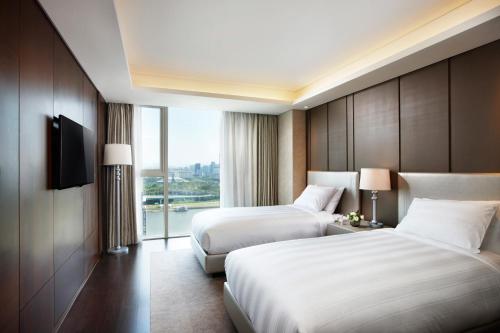 テジョンにあるLOTTE CITY HOTEL Daejeonのベッドが2つと窓があるホテルの部屋