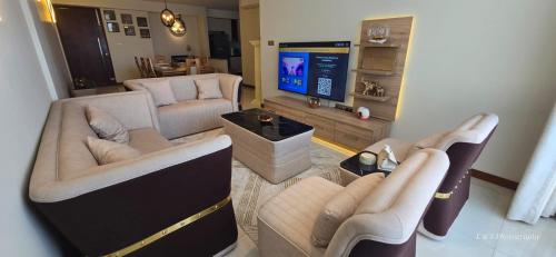 a living room with couches and a flat screen tv at Chilax By The Ocean in Dehiwala