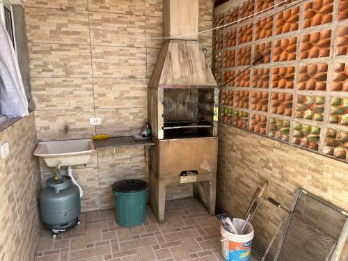 eine Küche mit Spüle und Arbeitsfläche mit Herd in der Unterkunft Sarau's Beach House Boracéia in Boracéia