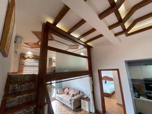 a living room with a vaulted ceiling and a couch at Zhangjiajie Han Exotic Inn in Zhangjiajie