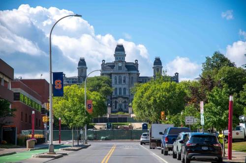 un gran edificio con coches aparcados en una calle de la ciudad en Westcott 2BD Apt in Mansion mins SU & JMA Dome, en Syracuse