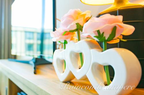 a vase of flowers sitting on a counter with roses at Raincondo Ampere in Cha Am