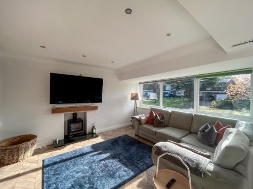 a living room with a couch and a flat screen tv at Hamble Haven in Lower Swanwick