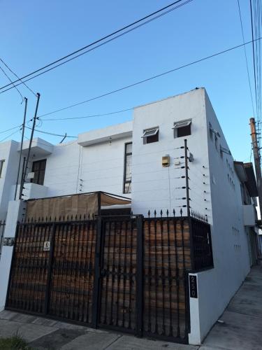a white building with a fence in front of it at Casa Ana Victoria in Morelia