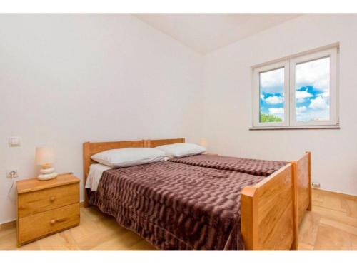 a bedroom with a bed and a window at Villa Dalmacija in Brištane