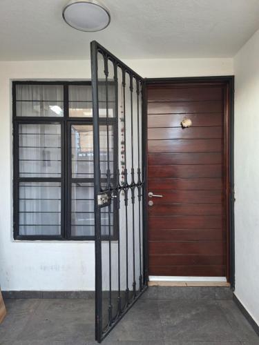 a wooden door with a metal gate in front of it at Casa Ana Victoria in Morelia