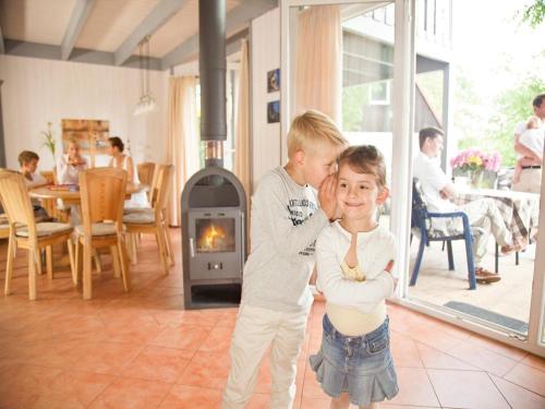 two children standing in a living room with a fireplace at Exklusives Schwedenhaus in Mirow in Granzow