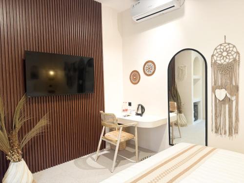 a bedroom with a desk and a tv on a wall at Canggu Villas Family Yogyakarta in Ngaglik