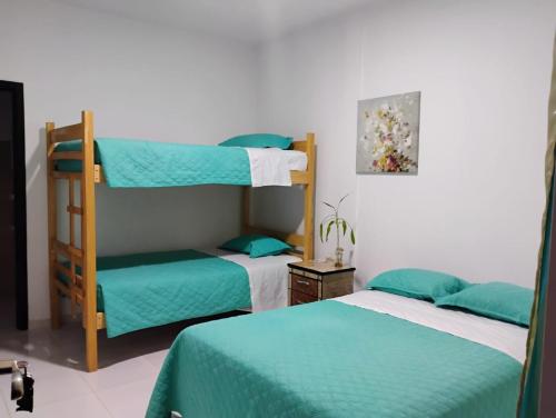 ein Schlafzimmer mit zwei Etagenbetten und einem Stuhl in der Unterkunft Hosteria La Veleta, Playas in Playas