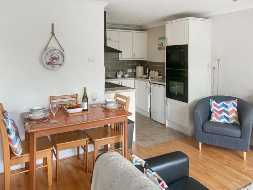 モリオンにある6 The Coveのテーブルと椅子のあるキッチンとリビングルーム