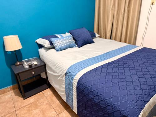 a bedroom with a bed with a blue wall at Apartamento - Casa Calderon, zona céntric in San Pedro Sula