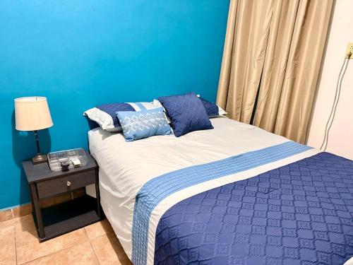 a bedroom with a bed with a blue wall at Apartamento - Casa Calderon, zona céntric in San Pedro Sula