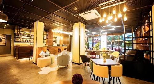 桂林市にあるImmersing Hotel Guilin Two Rivers and Four Lakes Dongxi Alleyの黄色い椅子とテーブルと椅子が備わるレストラン