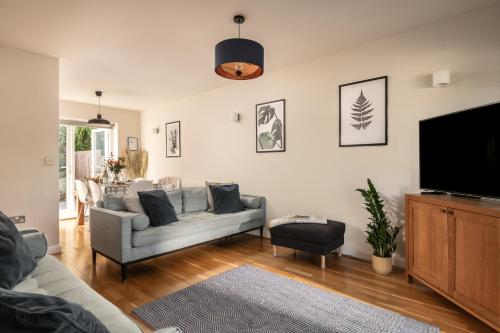 a living room with a couch and a flat screen tv at Coed y Felin in Conwy