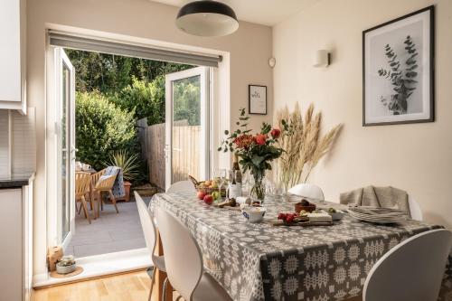 a dining room with a table with flowers on it at Coed y Felin in Conwy