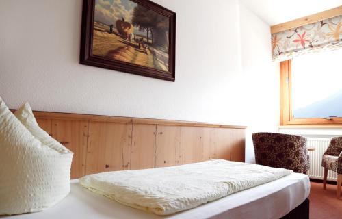 a bedroom with a bed and a picture on the wall at Hotel & Suites Glück Auf in Mayrhofen